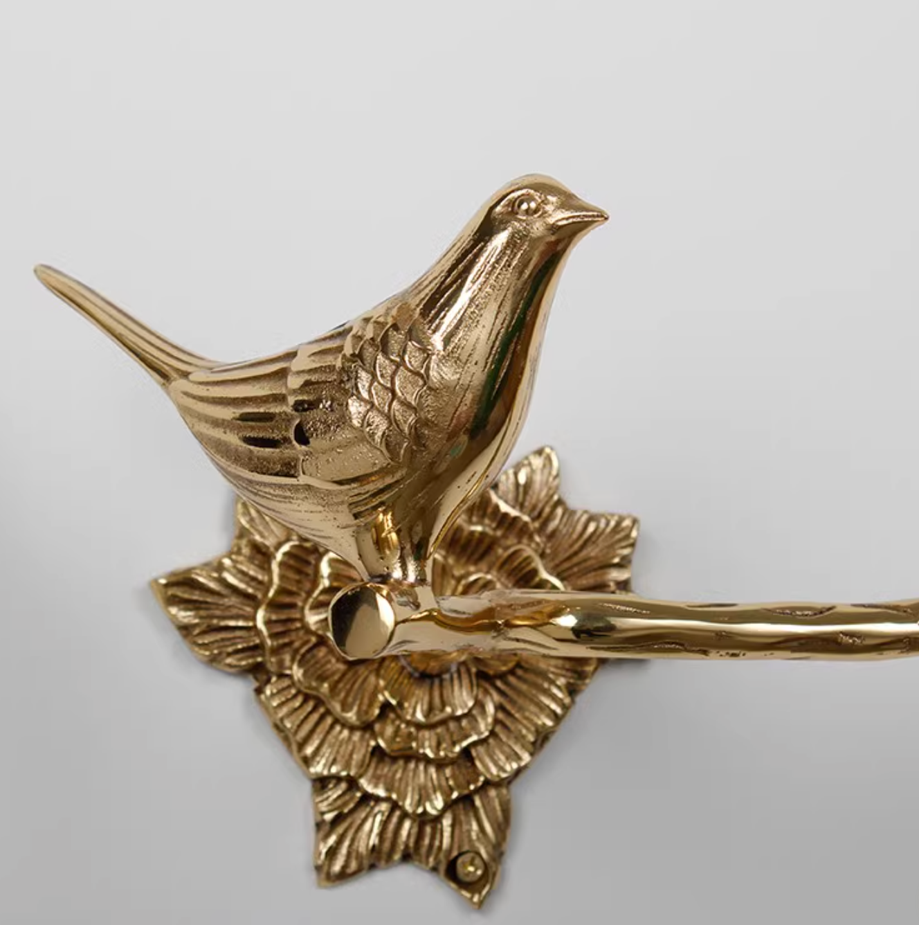 Brass bird toilet paper holder with floral base, part of the Brass Bird Bathroom Set.